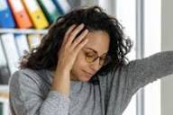 A person feeling dizzy after standing up suddenly while experiencing lightheadedness and blurred vision.